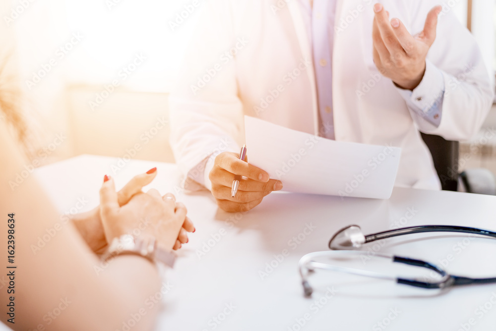 Doctor holding application form while consulting patient