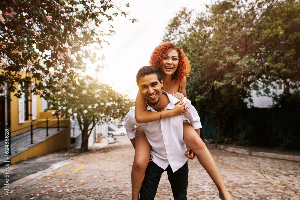 Young couple having fun in the street on a sunny day.