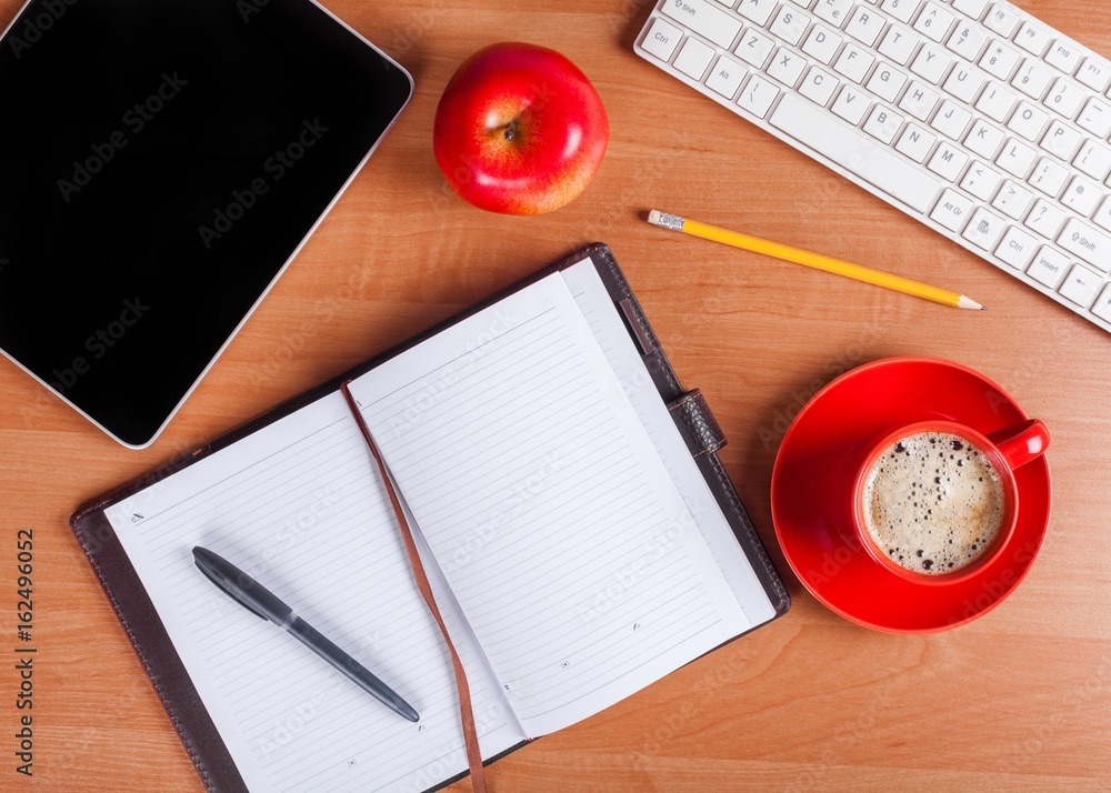 Office supplies on wooden table.