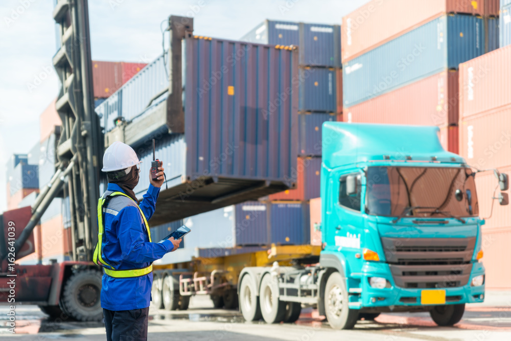 Foreman control loading Containers box from Cargo freight ship for logistics import export backgroun