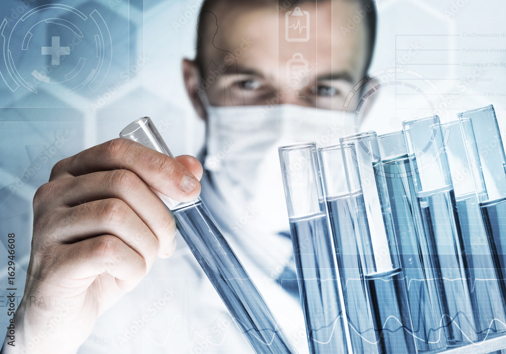 Young scientist mixing reagents in glass flask in clinical laboratory