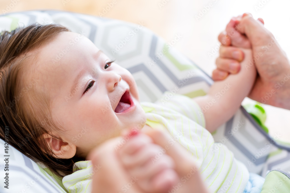 Happy baby boy playing with his parent in his house