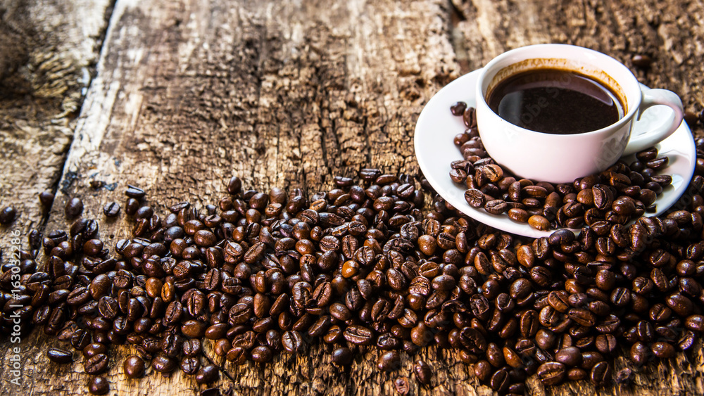 Coffee cup and coffee bean on a wooden table. Coffee in a white mug