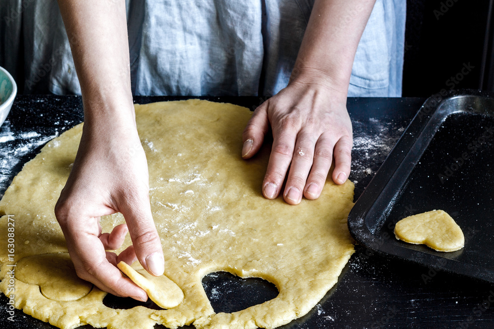 cooking homemade cookies with hands on dark background