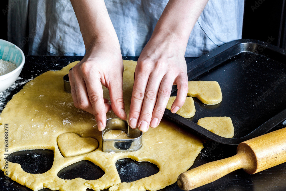 cooking homemade cookies with hands on dark background