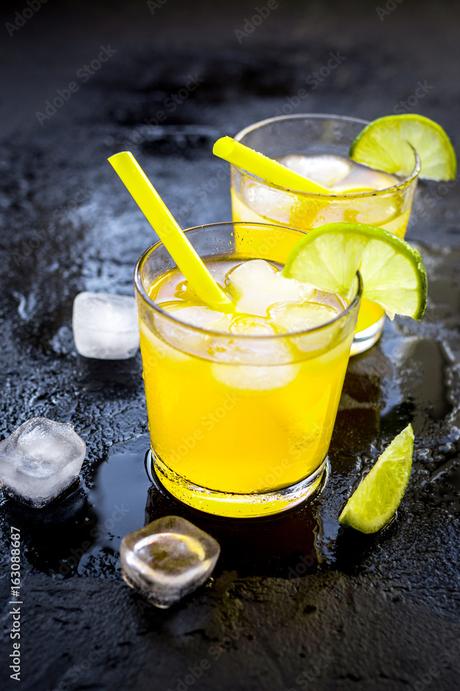 Alcohol cocktails with lime and ice on dark background