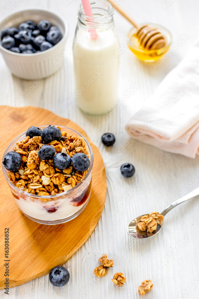 Fitness breakfast with granola, milk and honey on white backgrou