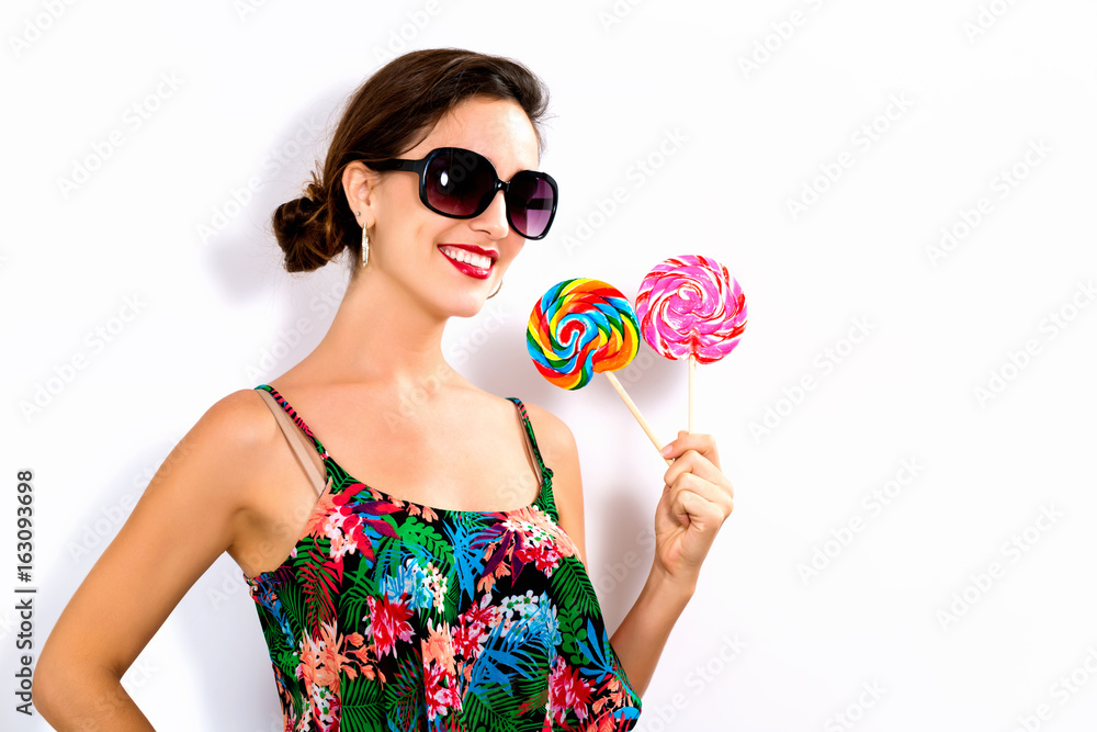 Young woman holding lollipops on a white background