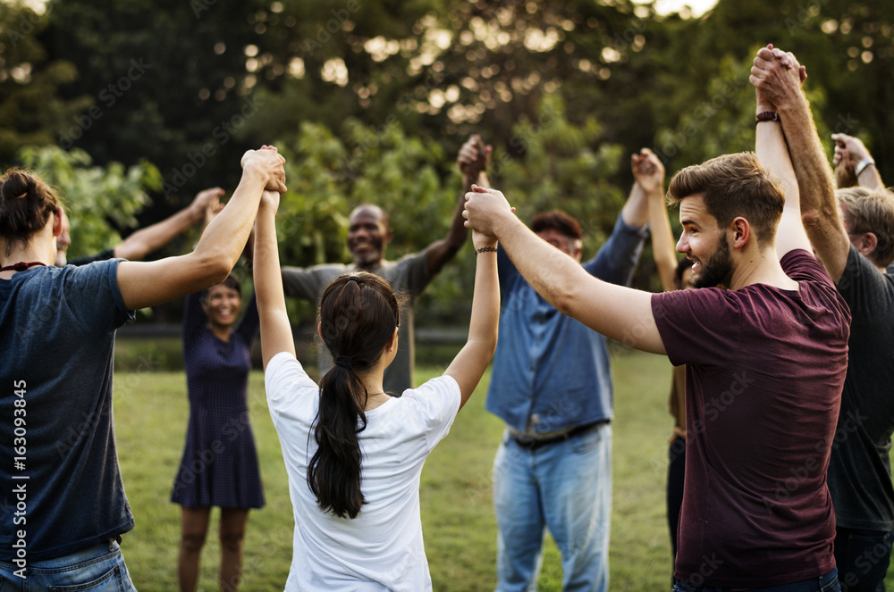 Group of people holding hand together in the park