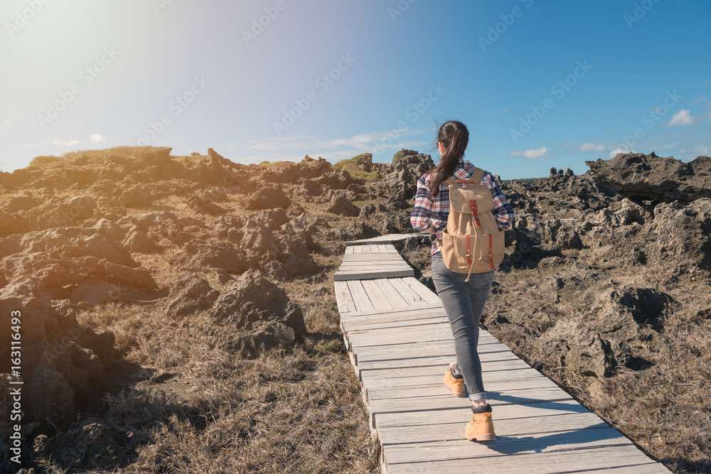 亚洲旅行者沿着木路行走