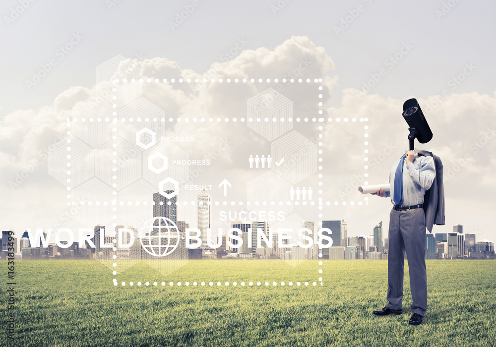 Camera headed man standing on green grass against modern citysca