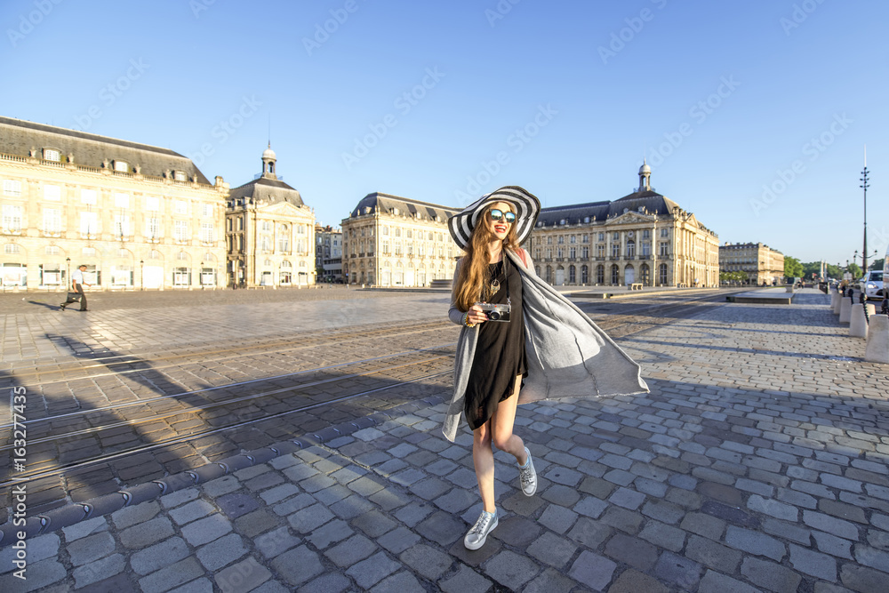 Lifestyle portrait of a woman tourist walking with photocamera on the famous de la Bourse square in 