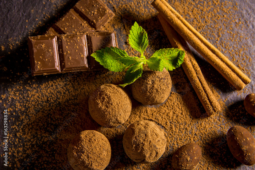 Chocolate truffle. Chocolate sweets on a table with mint and vanilla.