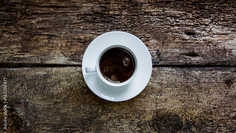 Hot cup of coffee on a wooden table. Coffee in a white mug