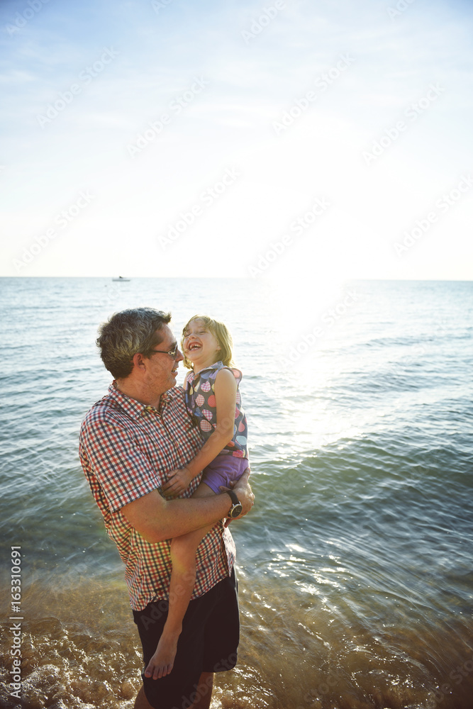 Caucasian father daughter enjoying summer time together at the beach