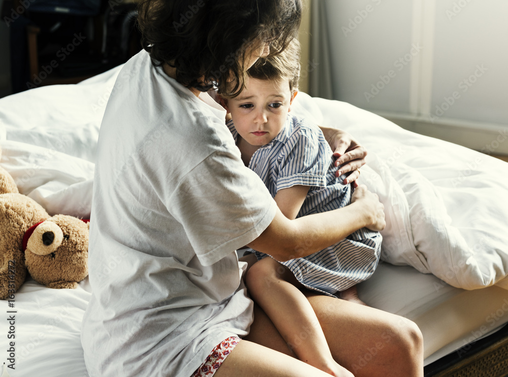 Mother hug and consoling the little boy from nightmare