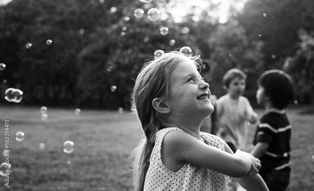 Children is playing bubbles in a park