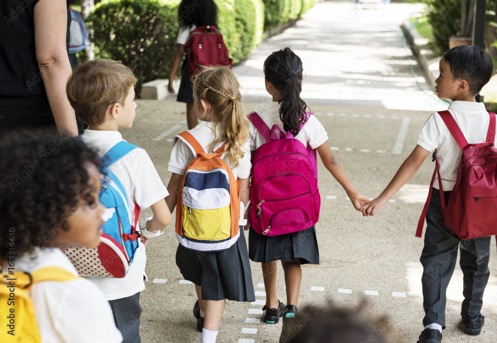 一群不同的幼儿园学生手牵手站在一起