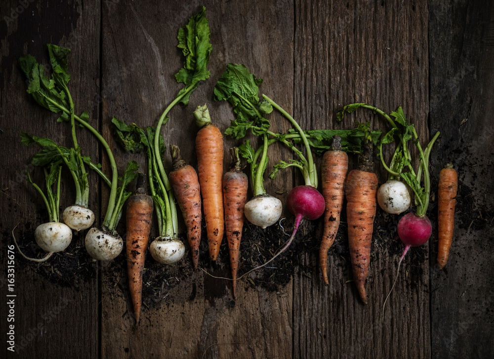 Aerial view of carrots and beets on wooden table