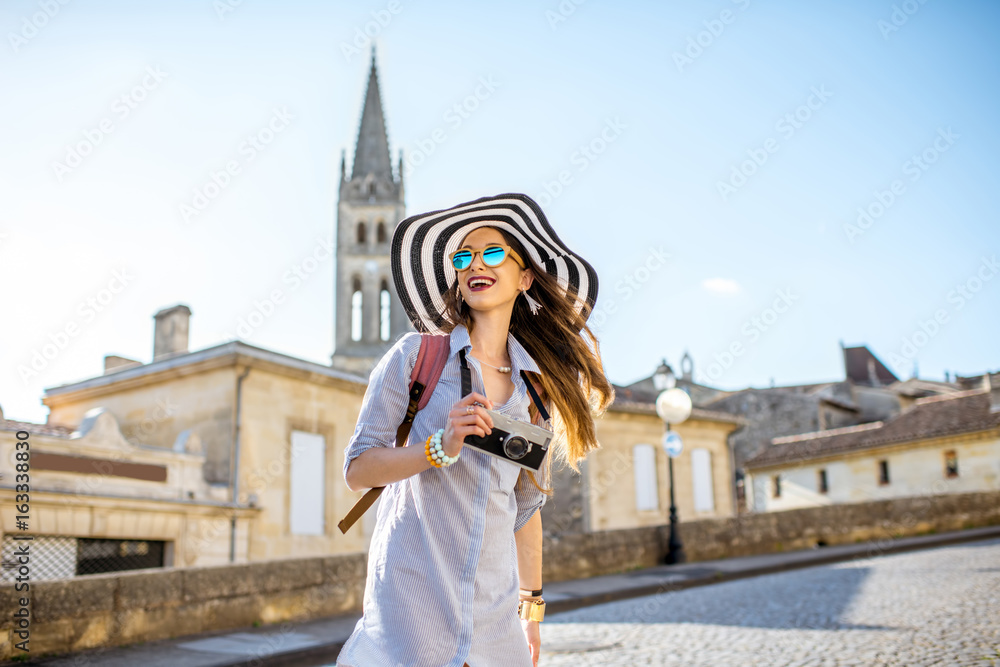 年轻的女游客走在弗拉波尔多地区著名的圣埃米利翁村的老街上