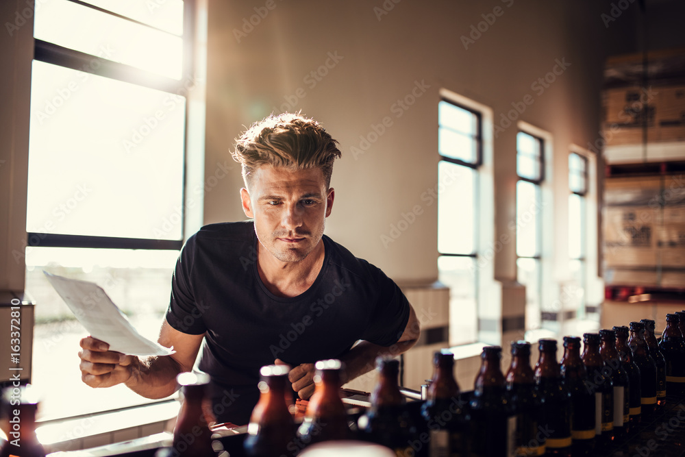 Brewery factory worker examining the quality of craft beer