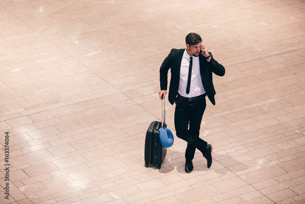 Business traveler making a phone call while waiting for flight