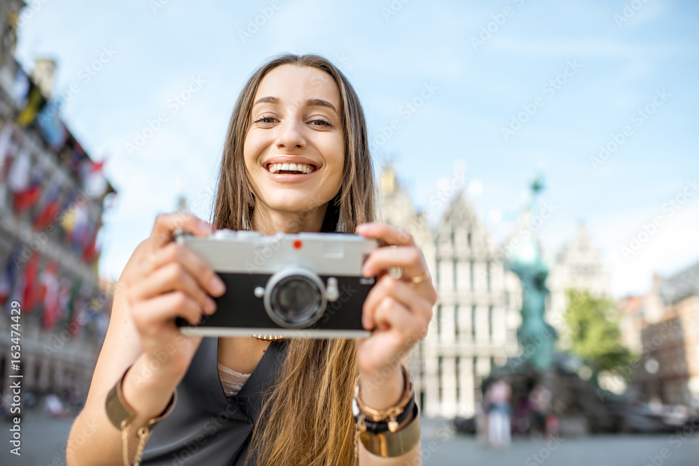 Portrait of a young woman tourist with photo camera on the Great Market square in Antwerpen city in 