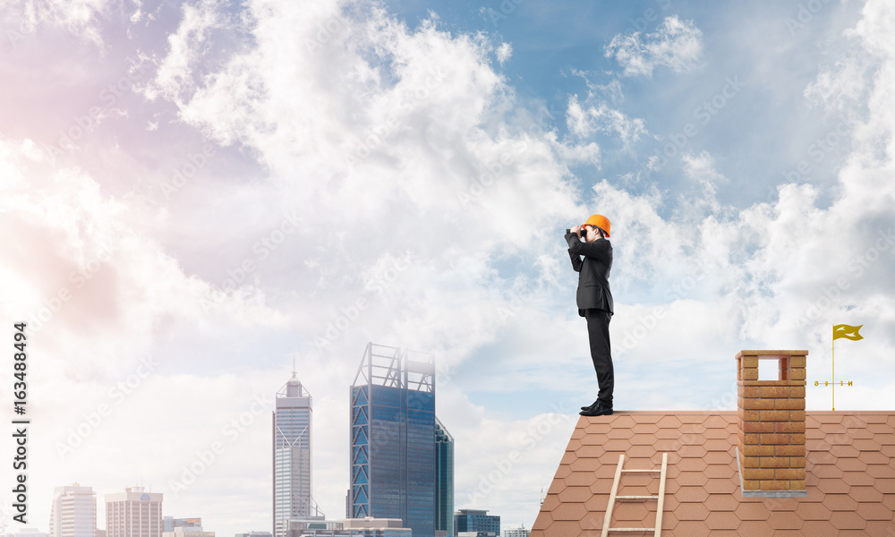 Engineer man standing on roof and looking in binoculars. Mixed media