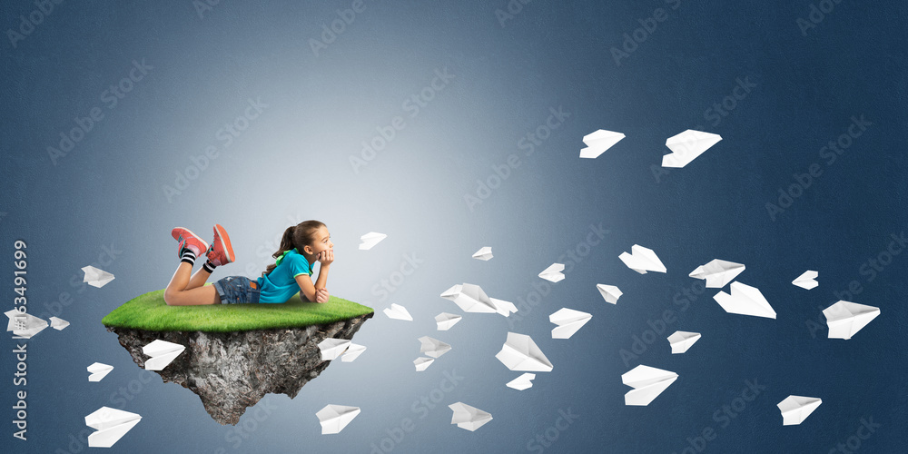 Concept of careless happy childhood with girl and paper planes flying around