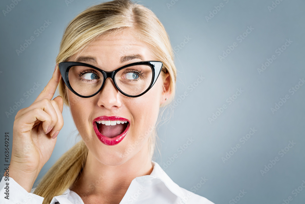 Young businesswoman in a thoughtful pose on a gray background