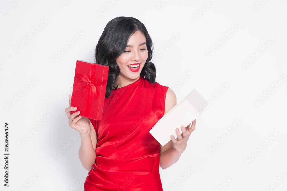 Pretty young glamorous asian woman dressed in red dress with a present