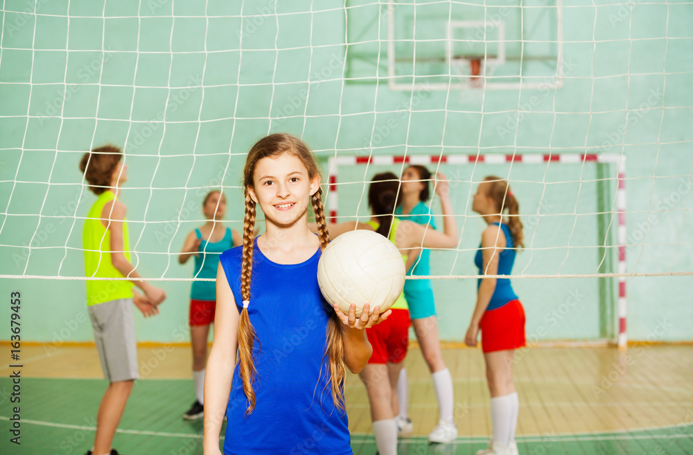 Happy teen girl with ball during training