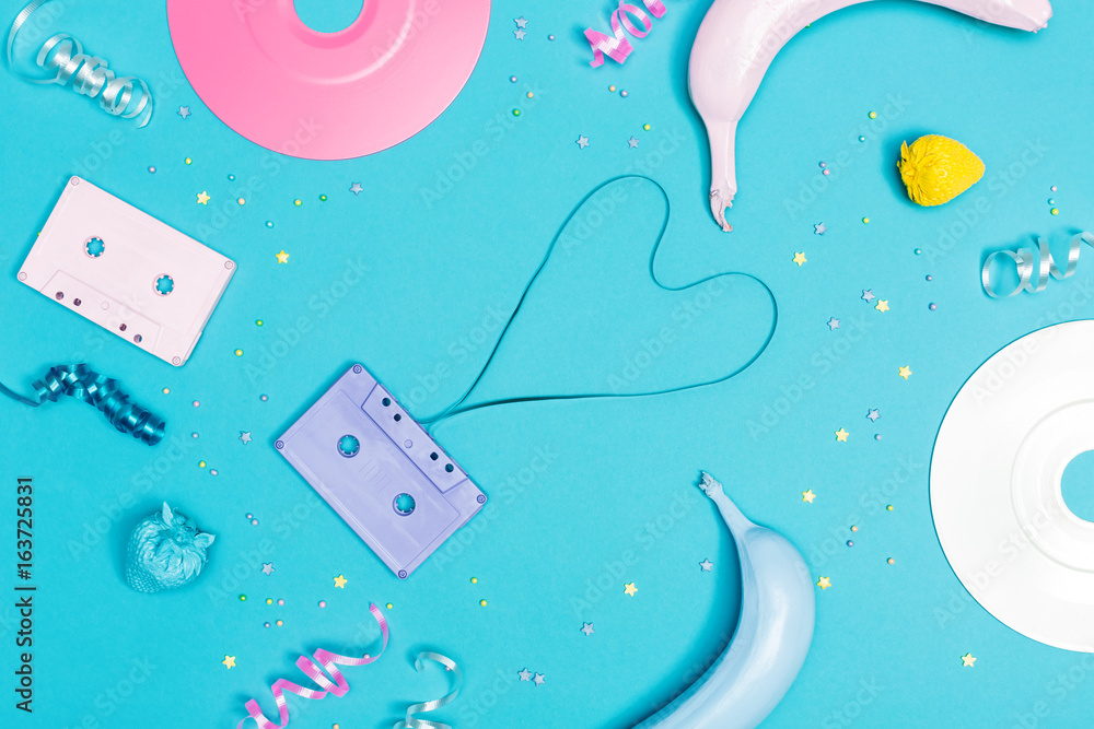 Music flat lay objects with vinyl records and cassette tapes on a blue background