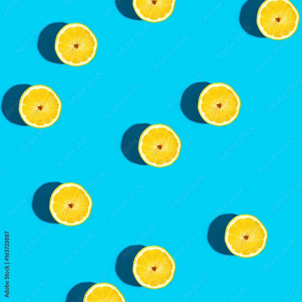 Fresh lemon pattern on a vivid blue background flat lay