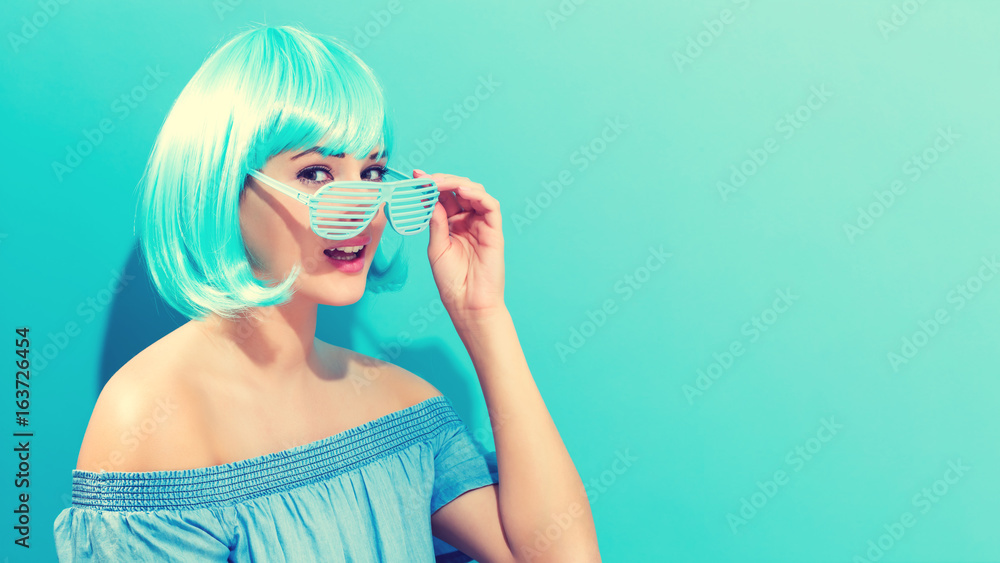 Beautiful woman in a bright blue wig on a blue background