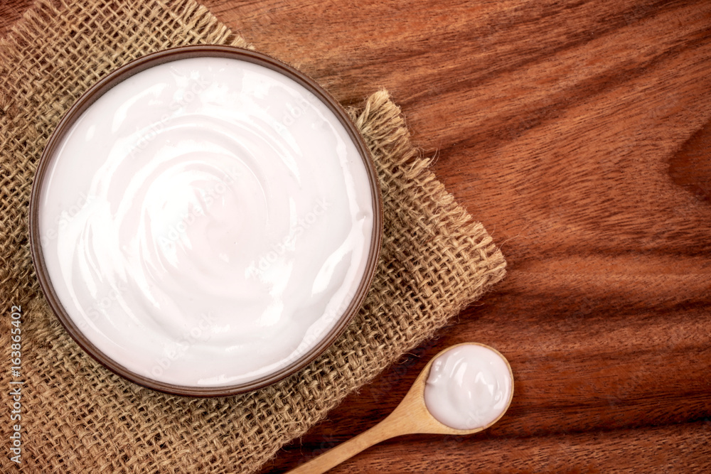 White creamy homemade yogurt on the wooden table , top view or overhead shot