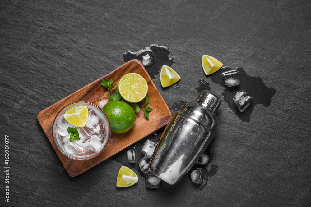 Mojito cocktail with lime and mint in glass on a grey stone background