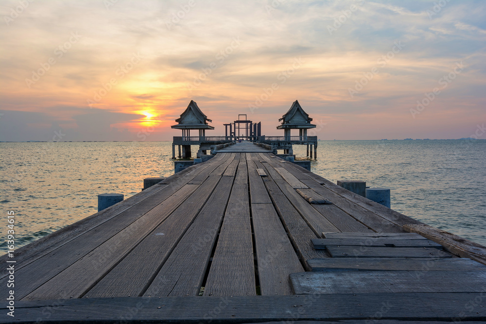 The sun reflected off the wooden bridge that stretches into the sea.In Chonburi Thailand.