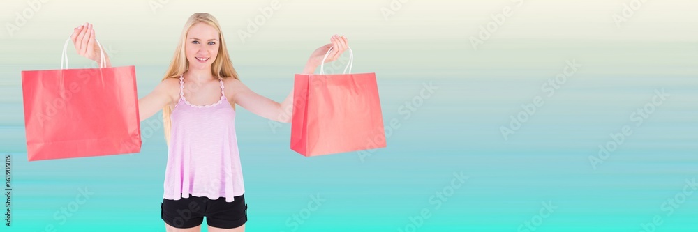 Shopper with red bags against blurry light blue background