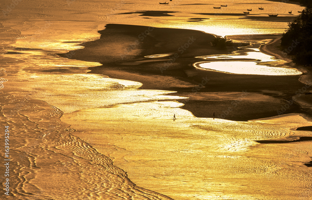 Ocean and golden light on the beach at dusk.