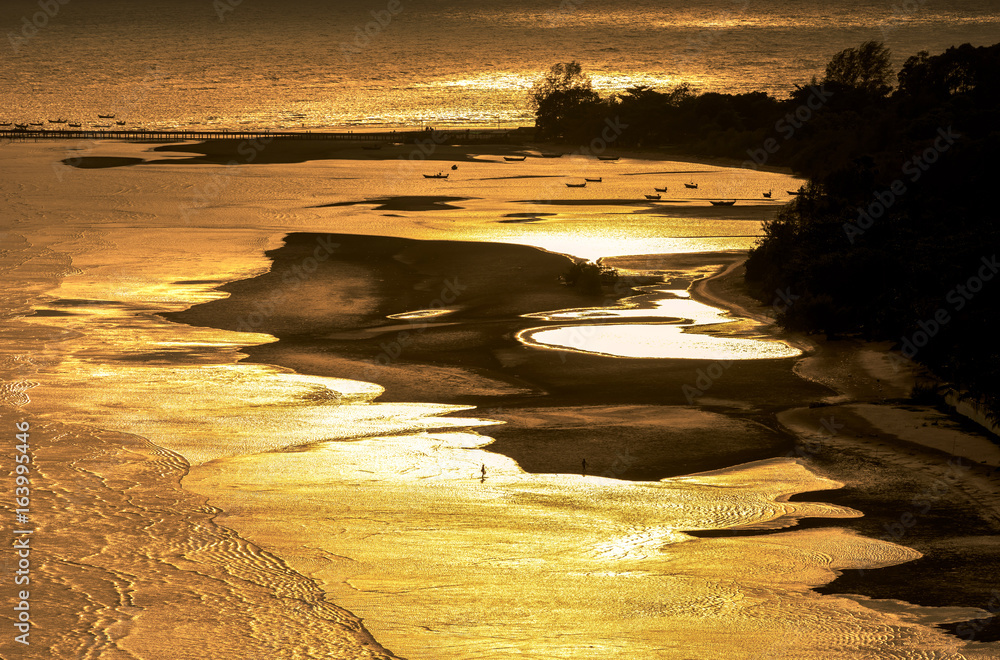 Ocean and golden light on the beach at dusk.