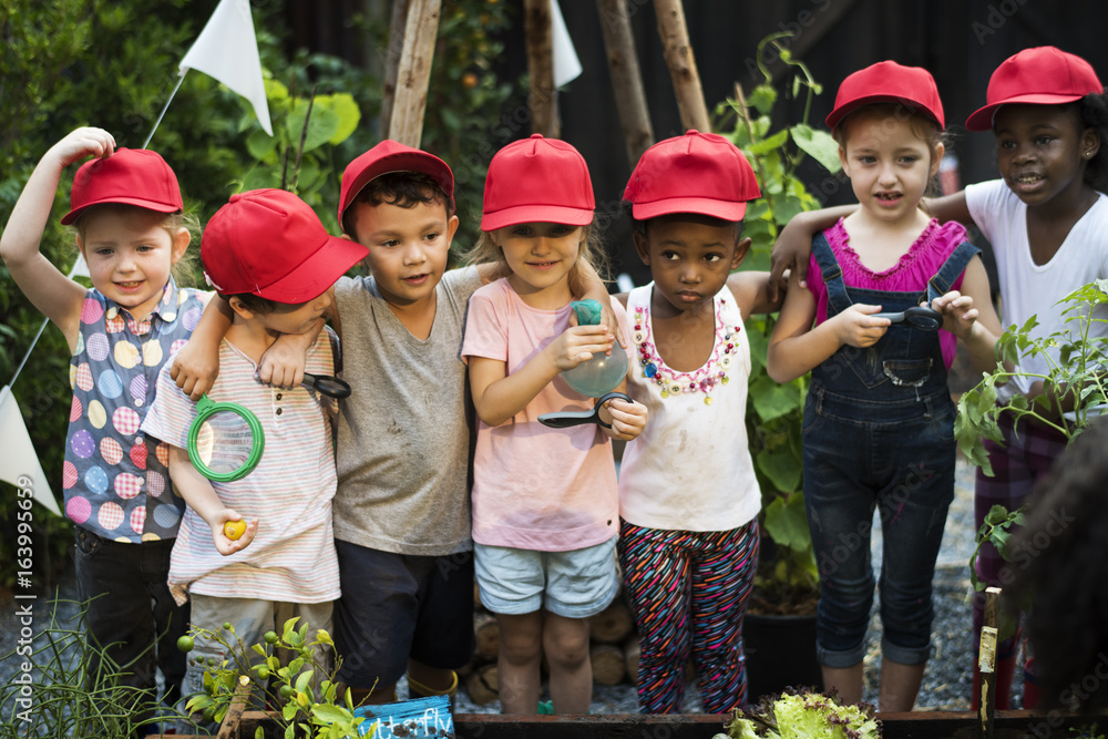 Group of kindergarten kids learning gardening outdoors