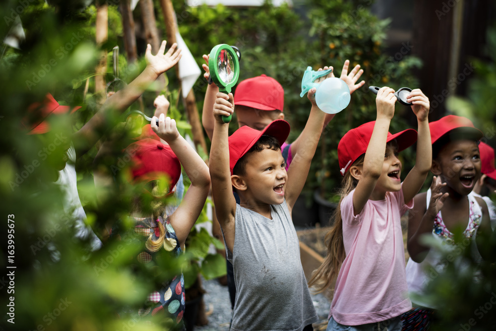 Group of kindergarten kids learning gardening outdoors