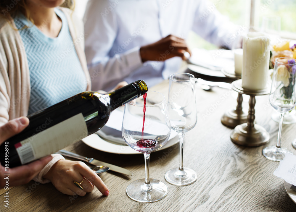 Waiter Poring Serving Red Wine to Customers in a Restaurant