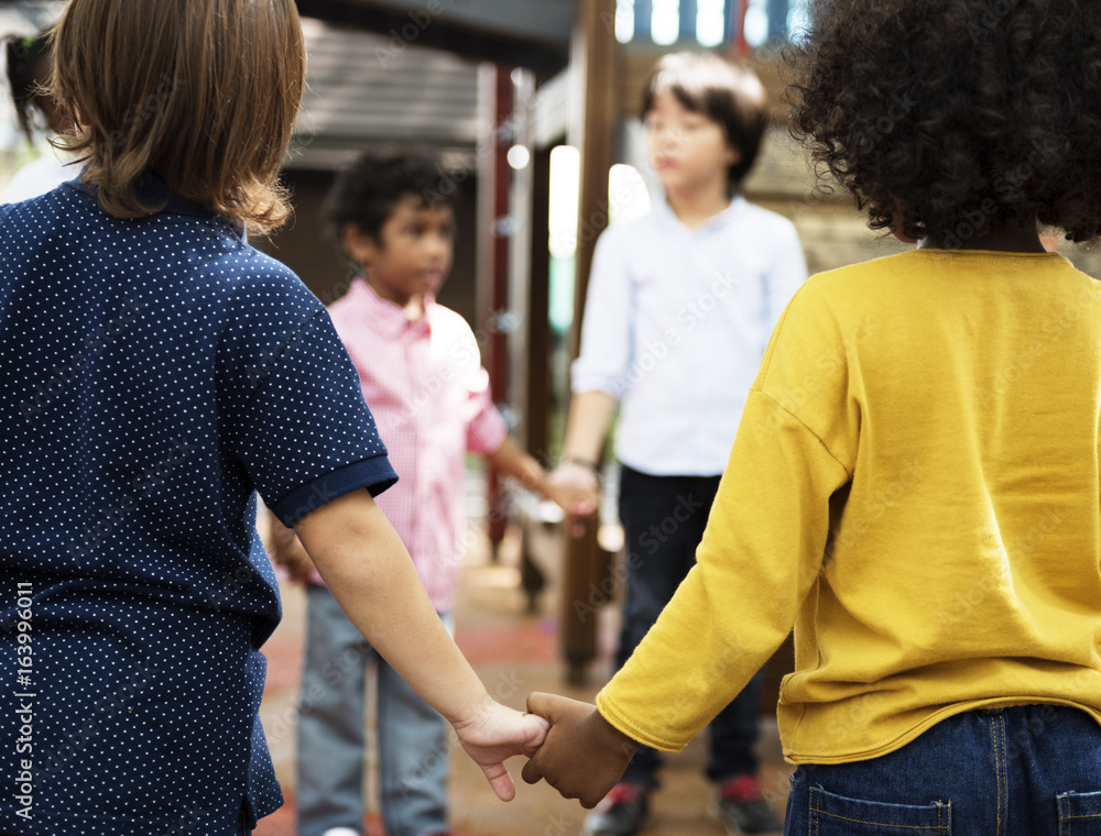 一群不同的幼儿园学生手牵手站在一起