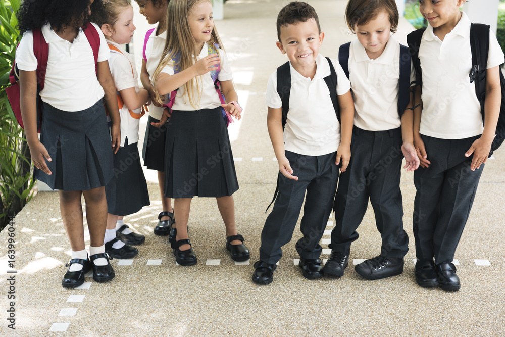 一群不同的幼儿园学生在学校里站在一起