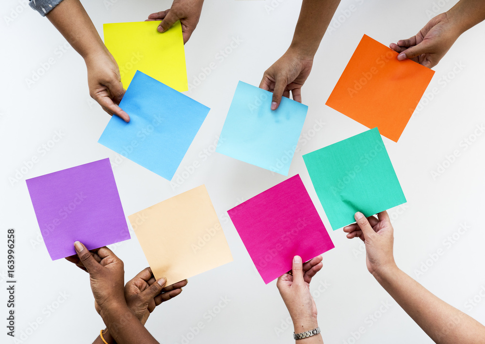 Hands Holding Multi Colors of Papers on White Background