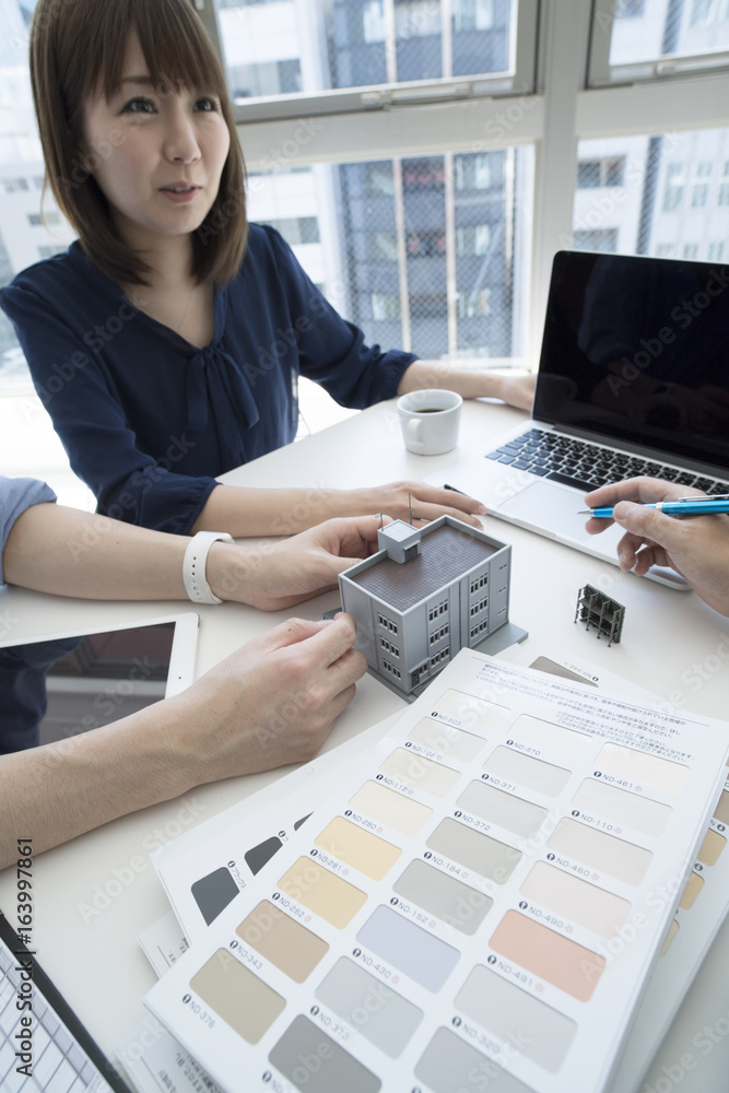 Businessmen are meeting while watching models of buildings