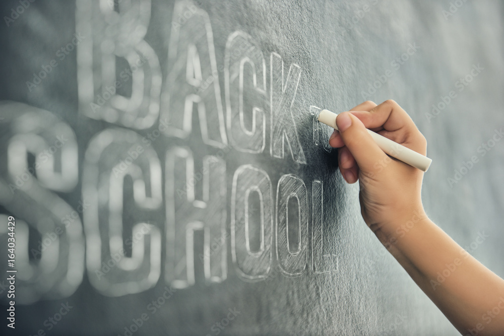 child is writing on blackboard