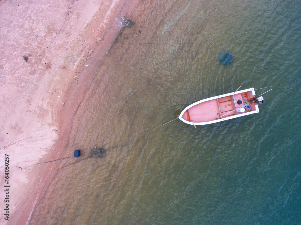 Fishing boat floating in the sea. The beautiful bright blue water in a clear day.